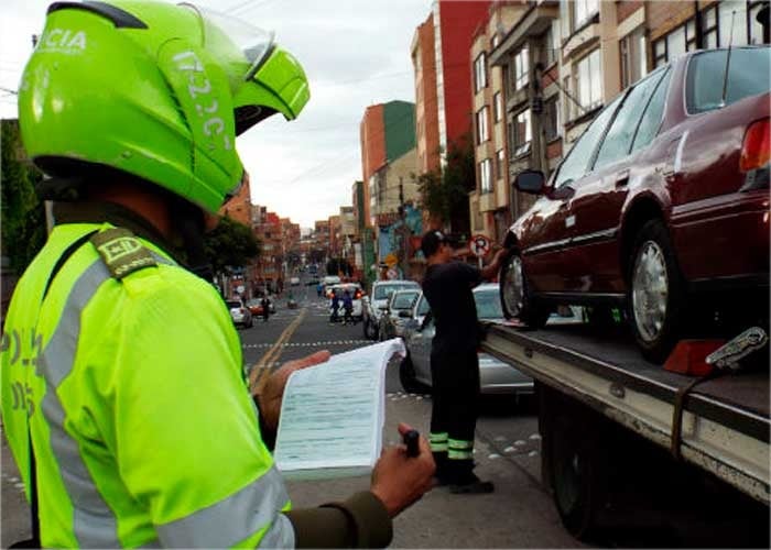 Policía con moto - El negociazo de inmovilizar carros y motos en Bogotá al que la Contraloría le puso la lupa